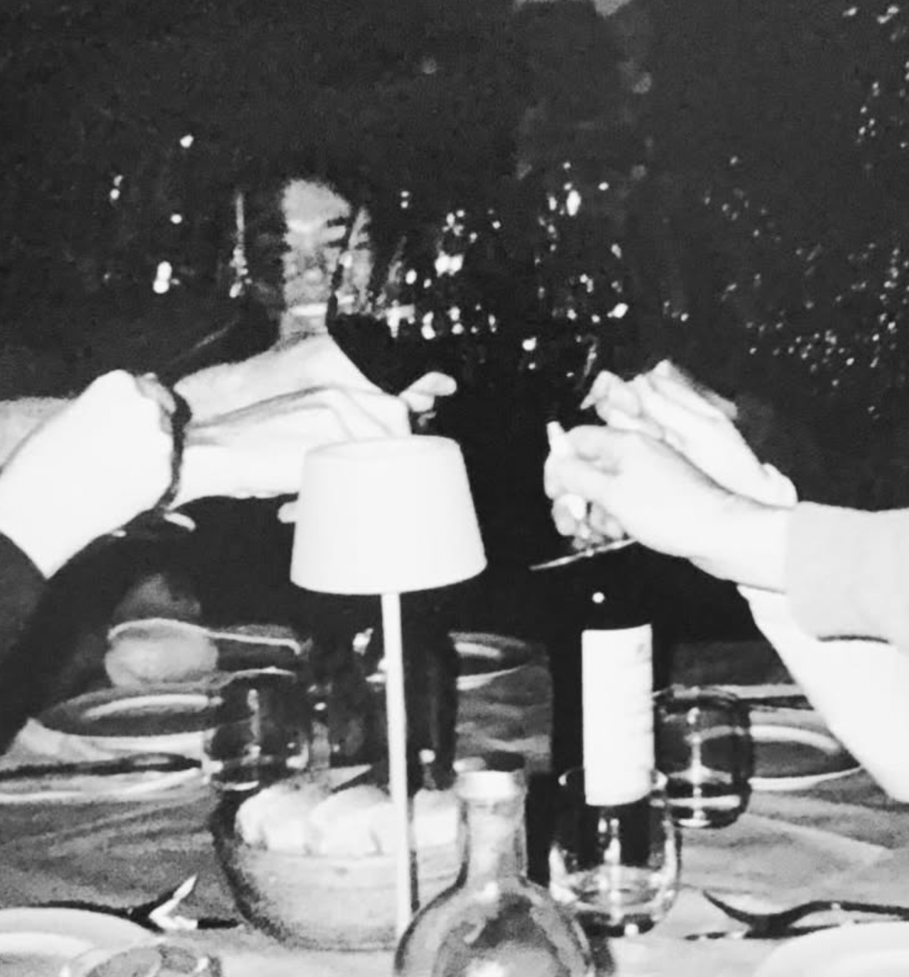 A dinner table set for a small group, seen in black and white